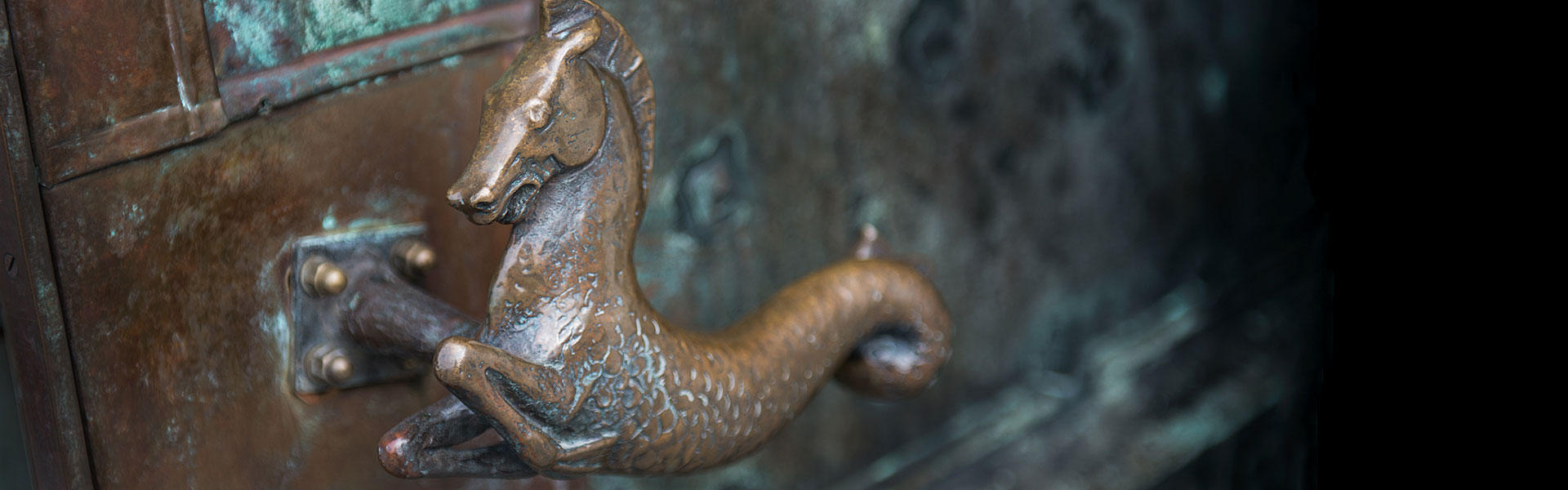 Närbild av sjöhästformat dörrhandtag.