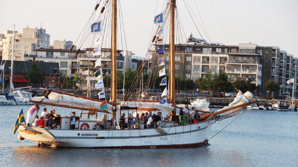 Klara Marie är ett segelfartyg med två master. Skrovet är vitmålat medan masterna är ljusbruna. Seglen är nedtagna eftersom fartyget är på väg in i en hamn. Ombord syns en stor grupp passagerare och besättning. 