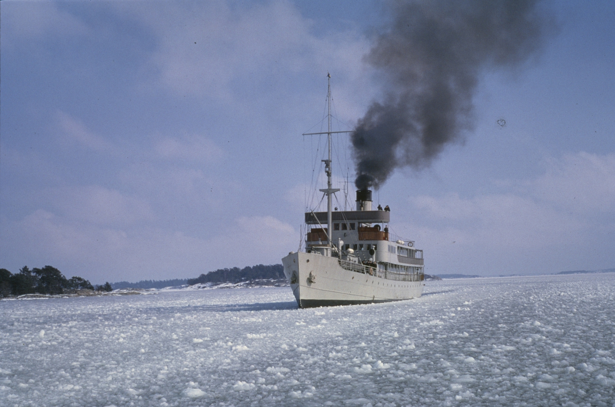 Marieholm är ett större passagerarfartyg med två salongdäck samt ventiler längs hela skrovet. Kommandobryggan sticker upp en våning ovanför passagerarutrymmena. På bilden är fartyget ute och kör vintertid, svart rök kommer från skorstenen på det ångdrivna fartyget. 