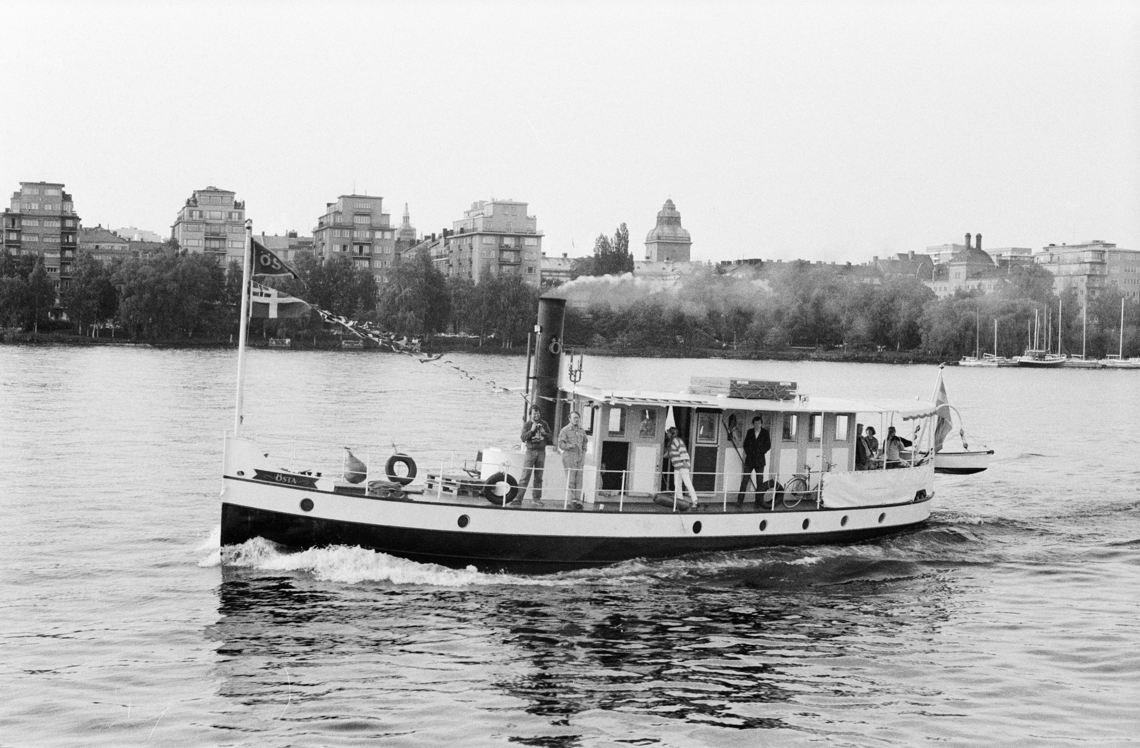Östa är en bogserbåt med svart skrov med vit rand längs relingen. Midskepps syns en skorsten och bakom den styrhytt sammanbyggd med en salong. På den svartvita bilden är fartyget ute och kör på Riddarfjärden i Stockholm. 