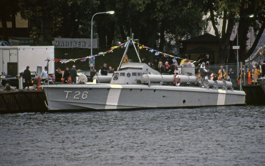 T26 är ett gråmålat militärt fartyg, en motortorpedbåt i stål. Hon har torpedtuber på däck och sitt namn målat i vitt på skrovet i fören. T26 ligger vid kajen på bilden och har ett flaggspel från fören till aktern.