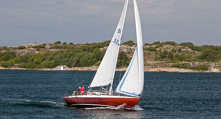 Fantasia är en havskryssare i mahogny med både för- och storseglet uppe. Hon går för fullt i skärgården.