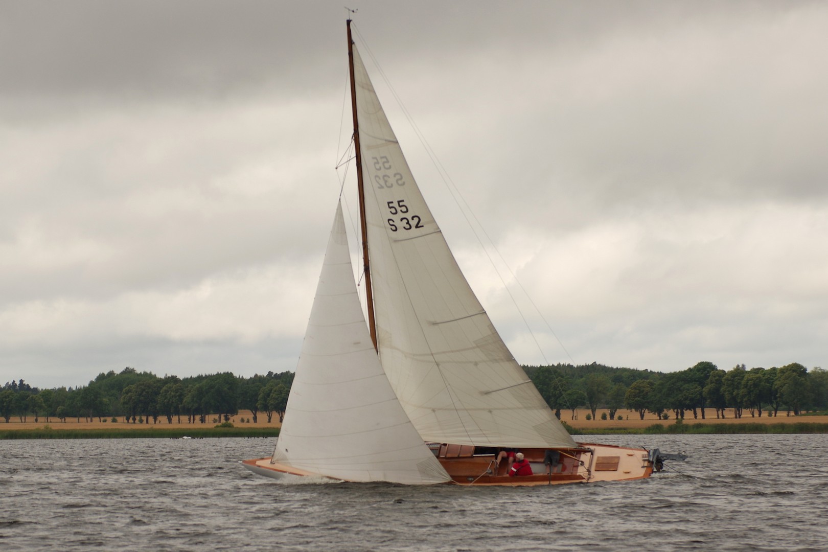 Maritza är en skärgårdskryssare i furu som syns kryssa i god vind. Hon har mycket vind i storseglet och focken. I aktern syns en utombordare. 